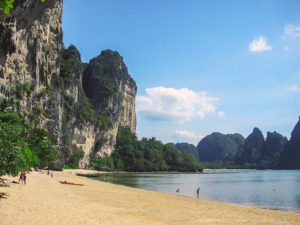 view of a beach with golden sand backed by high limestone cliffs