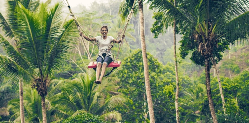 a girl on a zipline swing in forest environment