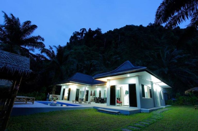 holiday pool villa in natural surroundings illuminated at night time