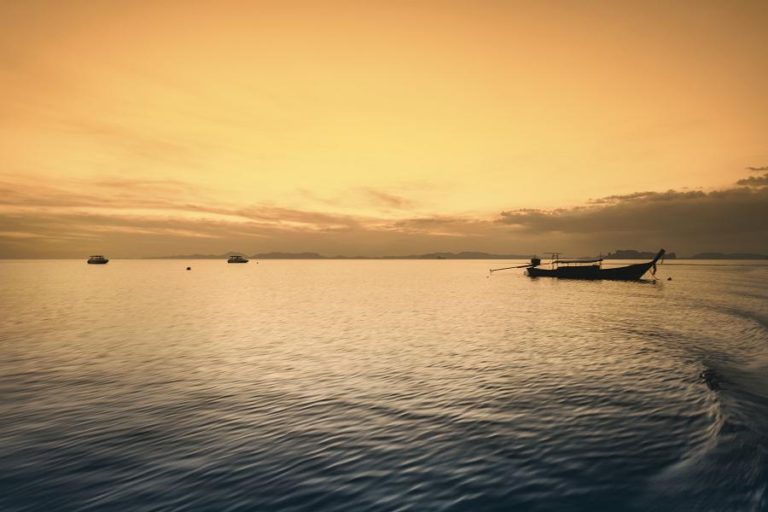 sea scape with traditional wooden fishing boats moored at sunset
