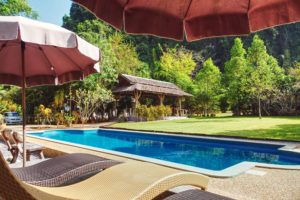 sun loungers, sun umbrella and lawns around a swimming pool