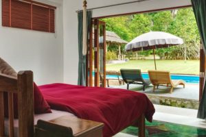 View from bedroom to a swimming pool and garden