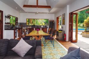 coloufully decorated dining and kitchen area with views to a swimming pool