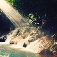 sun shafts illuminate a natural cascade