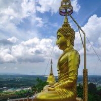 a big golden buddha statue on a mountain top in Krabi Thailand